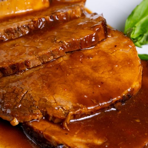 Fatias de carne assada na panela de pressão cobertas com molho