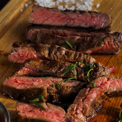 Picanha na airfryer fatiada sobre tábua de madeira com sal grosso